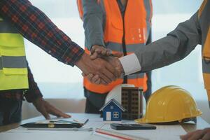 Construction and structure concept of Engineer or architect meeting for project working with partner and engineering tools on model building and blueprint in working site, contract for both companies. photo