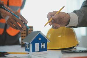 Construction and structure concept of Engineer or architect meeting for project working with partner and engineering tools on model building and blueprint in working site, contract for both companies. photo