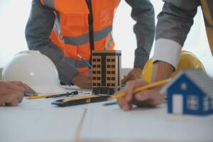 Construction and structure concept of Engineer or architect meeting for project working with partner and engineering tools on model building and blueprint in working site, contract for both companies. photo