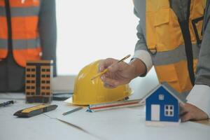 Construction and structure concept of Engineer or architect meeting for project working with partner and engineering tools on model building and blueprint in working site, contract for both companies. photo