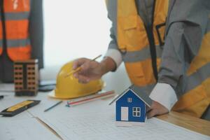 Construction and structure concept of Engineer or architect meeting for project working with partner and engineering tools on model building and blueprint in working site, contract for both companies. photo
