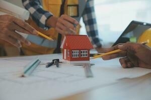 Construction and structure concept of Engineer or architect meeting for project working with partner and engineering tools on model building and blueprint in working site, contract for both companies. photo