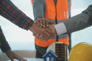 Construction and structure concept of Engineer or architect meeting for project working with partner and engineering tools on model building and blueprint in working site, contract for both companies. photo
