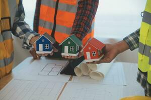 Construction and structure concept of Engineer or architect meeting for project working with partner and engineering tools on model building and blueprint in working site, contract for both companies. photo
