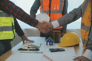 Construction and structure concept of Engineer or architect meeting for project working with partner and engineering tools on model building and blueprint in working site, contract for both companies. photo