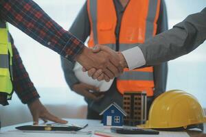 Construction and structure concept of Engineer or architect meeting for project working with partner and engineering tools on model building and blueprint in working site, contract for both companies. photo