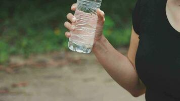 potabile acqua, fitness e esercizio donna dopo gli sport correre e formazione nel natura. allenamento, escursioni a piedi e a piedi sfida con un' bottiglia di un' femmina corridore nel estate pronto per in esecuzione per Salute video