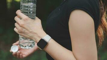 Trinken Wasser, Fitness und Übung Frau nach Sport Lauf und Ausbildung im Natur. trainieren, Wandern und Gehen Herausforderung mit ein Flasche von ein weiblich Läufer im Sommer- bereit zum Laufen zum Gesundheit video