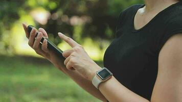 The athlete watches cardio, fitness in the city. A woman looks at sports and counts calories during training. Exercise coach on the street, healthy lifestyle. video