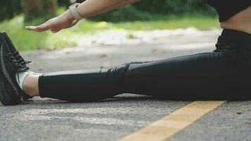 Young fitness woman runner stretching legs before run on city video