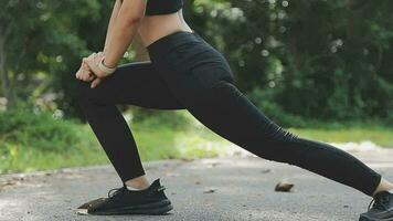 Young fitness woman runner stretching legs before run on city video