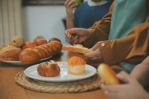Caucasian attractive couple baking bakery with son in kitchen at home. Happy Family-father, mother and young boy having fun spending time together using ingredient making foods. Activity relationship. photo
