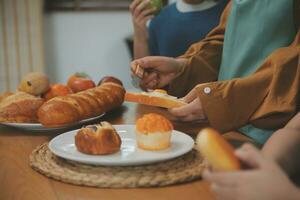 caucásico atractivo Pareja horneando panadería con hijo en cocina a hogar. contento padre de familia, madre y joven chico teniendo divertido gasto hora juntos utilizando ingrediente haciendo alimentos actividad relación. foto