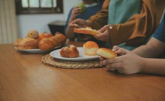 caucásico atractivo Pareja horneando panadería con hijo en cocina a hogar. contento padre de familia, madre y joven chico teniendo divertido gasto hora juntos utilizando ingrediente haciendo alimentos actividad relación. foto