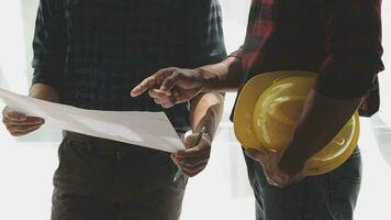 Image of team engineer checks construction blueprints on new project with engineering tools at desk in office. video