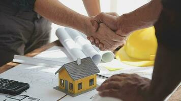 Image of team engineer checks construction blueprints on new project with engineering tools at desk in office. video