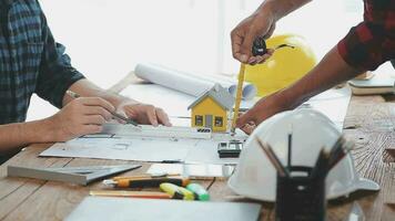 Image of team engineer checks construction blueprints on new project with engineering tools at desk in office. video