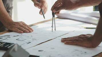 Image of team engineer checks construction blueprints on new project with engineering tools at desk in office. video