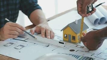 Image of team engineer checks construction blueprints on new project with engineering tools at desk in office. video