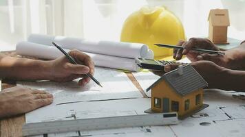 Image of team engineer checks construction blueprints on new project with engineering tools at desk in office. video