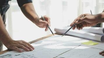 Image of team engineer checks construction blueprints on new project with engineering tools at desk in office. video