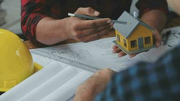 Image of team engineer checks construction blueprints on new project with engineering tools at desk in office. video