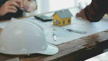 Image of team engineer checks construction blueprints on new project with engineering tools at desk in office. video