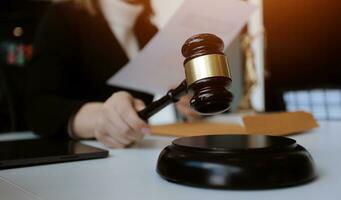 Male lawyer working with contract papers and wooden gavel on tabel in courtroom. justice and law ,attorney, court judge, concept. photo