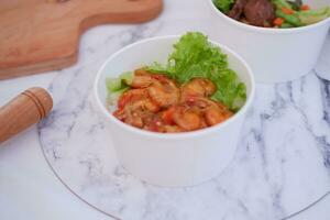 Shrimp salad in white bowl table background, top view photo