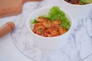 Shrimp salad in white bowl table background, top view photo