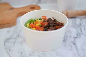 Rice with beef and vegetables in a white bowl table photo