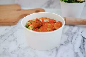 Fried chicken with sweet pepper and tomato in white bowl photo