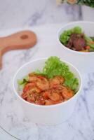 Shrimp salad in white bowlle table background, top view photo