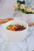 Rice with beef and vegetables in a white bowl table photo