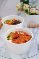 Fried chicken with sweet pepper and tomato in white bowl photo