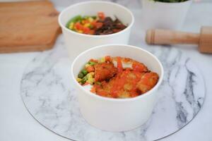 Fried chicken with sweet pepper and tomato in white bowl photo