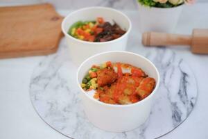 Fried chicken with sweet pepper and tomato in white bowl photo