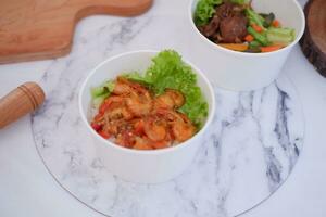 Shrimp salad in white bowlle table background, top view photo