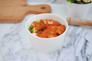 Fried chicken with sweet pepper and tomato in white bowl photo