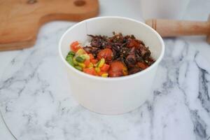 Rice with beef and vegetables in a white bowl table photo