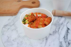 Fried chicken with sweet pepper and tomato in white bowl photo