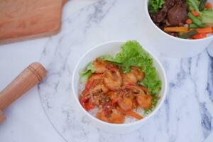 Shrimp salad in white bowlle table background, top view photo