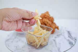 French fries, fried chicken and ketchup on white marble table. photo