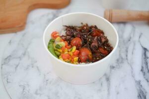 Rice with beef and vegetables in a white bowl table photo