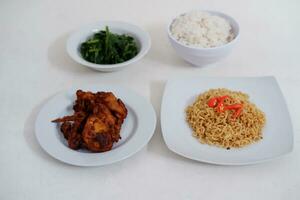 Instant noodle with fried chicken and rice on white plate photo