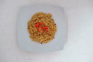 Instant noodle with fried chicken and rice on white plate photo