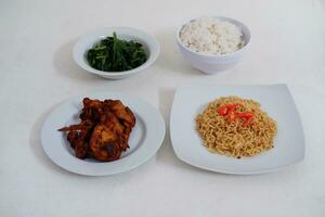 Instant noodle with fried chicken and rice on white plate photo