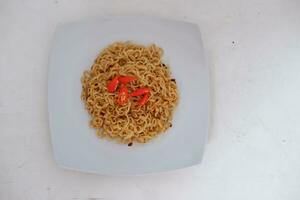 Instant noodle with fried chicken and rice on white plate photo