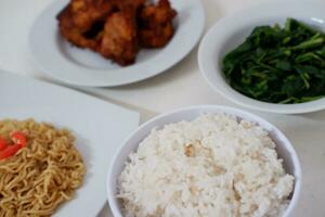 Instant noodle with fried chicken and rice on white plate photo