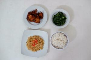 Instant noodle with fried chicken and rice on white plate photo